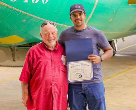 Aloft Academy Graduate standing in front of plane