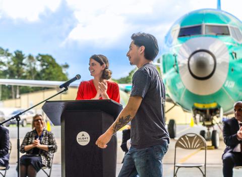 Person speaking in front of airplane